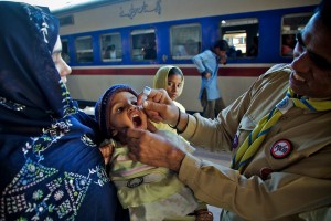 A Unicef worker administers polio vaccine at a Karachi tran station (image from the Unicef Facebook page)